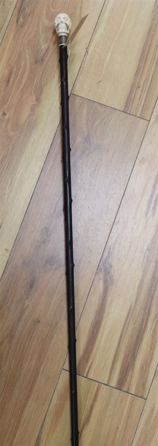 A Victorian ebonised walking cane with ivory skull hand-piece, length 87cm